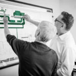 2 Mitarbeiter der SSN Gebäudetechnik in Wolfsburg prüfen einen Plan für Industrie-Lüftungslösungen